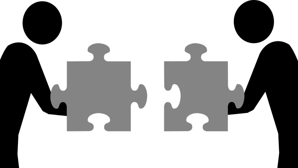 Illustration of two persons holding puzzle pieces.