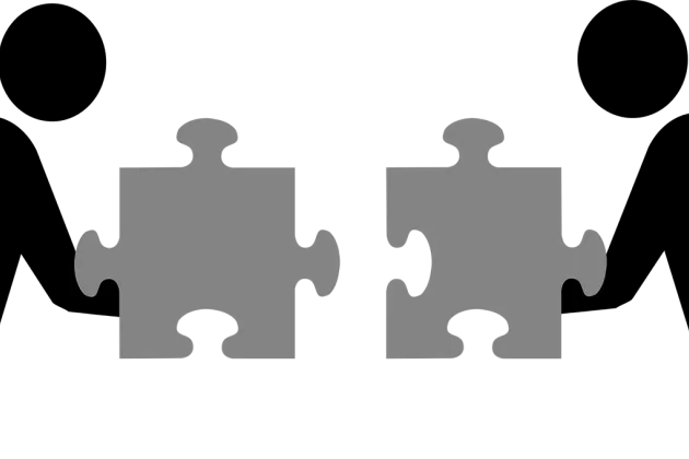 Illustration of two persons holding puzzle pieces.