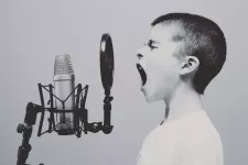 Photo of a young boy in front of a microphone