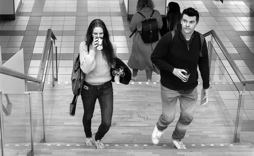 Two persons walking upstairs. Photo.