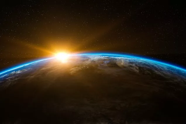 An illustration of a sunrise over the earth seen from space.