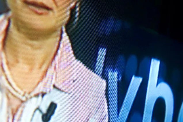 A photo of a TV showing a news broadcast.