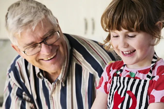 A grownup and a child are sitting beside each other. Photo.