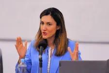 A person in a blue coat sitting at a table.