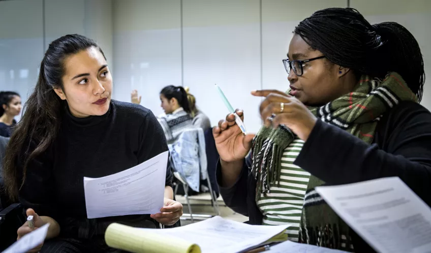Two students engaged in a conversation. Photo.
