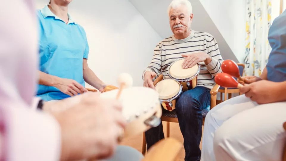 Äldre människor som spelar på musikinstrument. Foto.