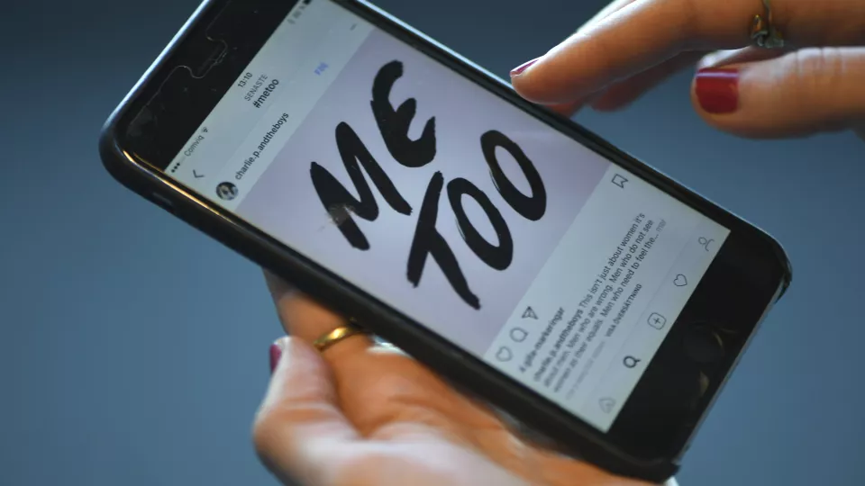 En mobiltelefon där det på skärmen står "Me too". Foto.