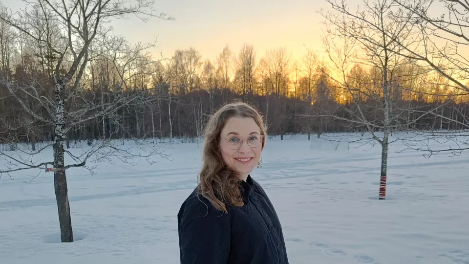 Porträttfoto av Ina med ett snölandskap i bakgrunden. Foto.