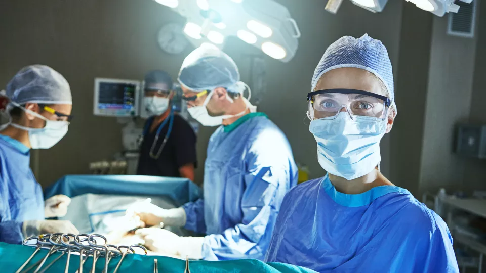 Fyra personer står i en operationssal. Foto.