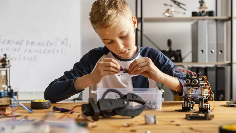 Ett barn bygger en tekniksak. Foto.