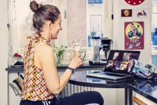 En kvinna sitter vid en dator och deltar i en digital AW. Foto.